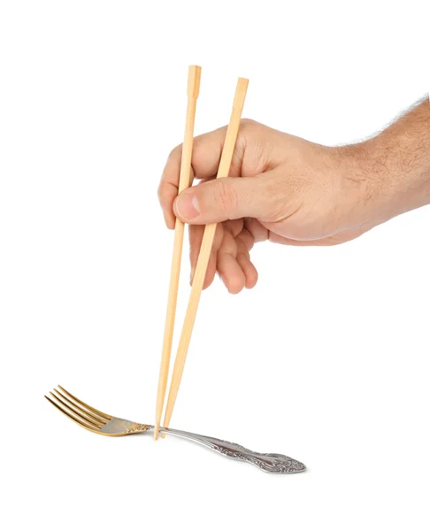 Рука с палочками для еды и вилкой — стоковое фото