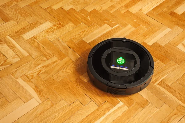 Robotic vacuum cleaner on parquet — Stock Photo, Image