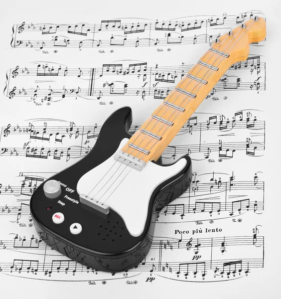 Toy guitar and music sheet — Stock Photo, Image