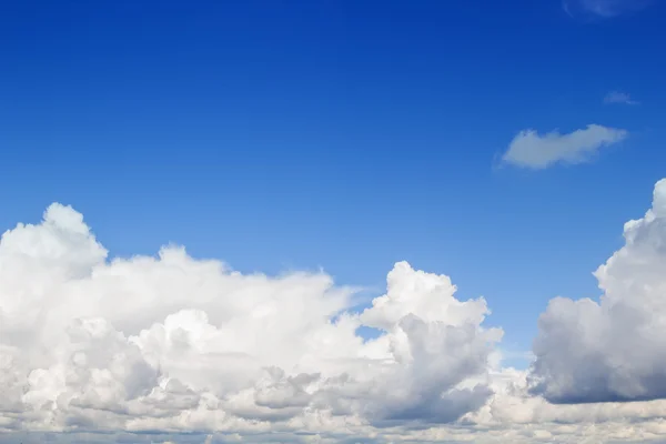 Blauwe lucht met pluizige witte wolken achtergrond. — Stockfoto