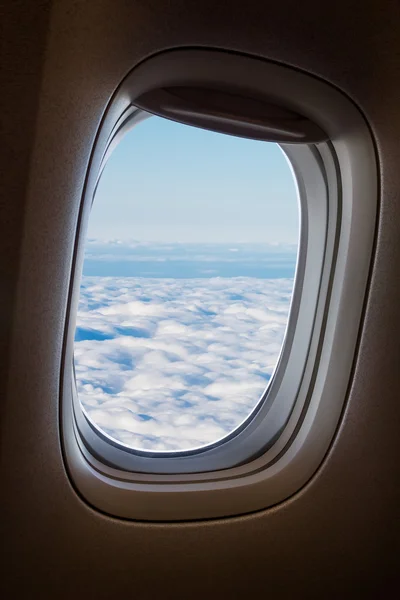 Plane window with blue sky and clouds outside. — Stock Photo, Image