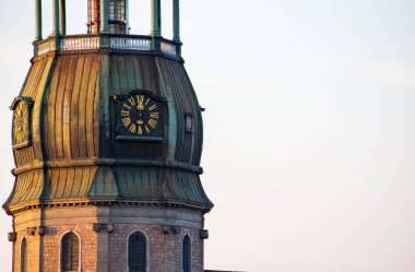 Riga 'nın sembolü, ortaçağ kilise kulesindeki eski saat çatılar arasında Avrupa mimarisi olan antik binalar.