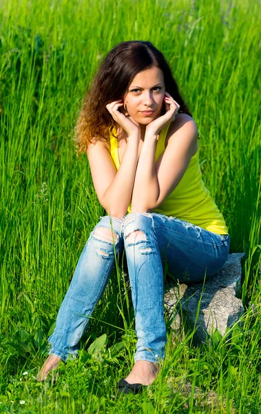 Jeune femme assise sur la pierre — Photo