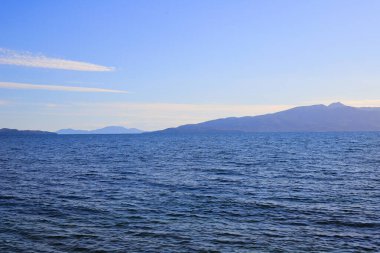 Mavili ve mavi gökyüzü olan İyon deniz manzarası