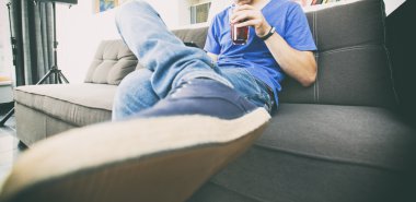 Kanepe kokteyl içme üzerinde genç adam