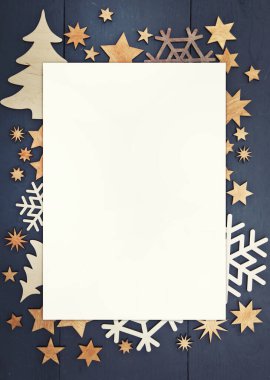 Güzel Noel arkaplan esprisi. Koyu ahşap masanın üzerinde küçük ahşap süslemeler var..