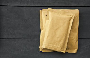 Tahta masanın üzerinde iki farklı boyutta kağıt zarf var.