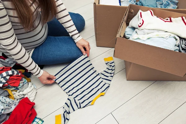 Mujer Embarazada Está Clasificando Ropa Del Bebé —  Fotos de Stock