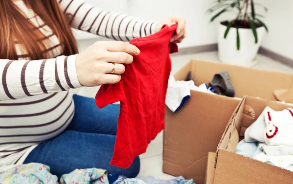 Mujer Embarazada Está Clasificando Ropa Del Bebé —  Fotos de Stock