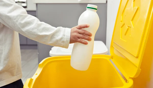 Der Junge Wirft Die Leere Plastikflasche Einen Von Drei Mülltonnen — Stockfoto