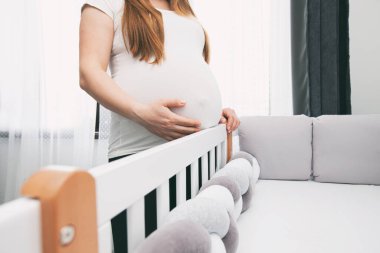 Hamile kadın yeni doğan çocuğu için karyola hazırlıyor.