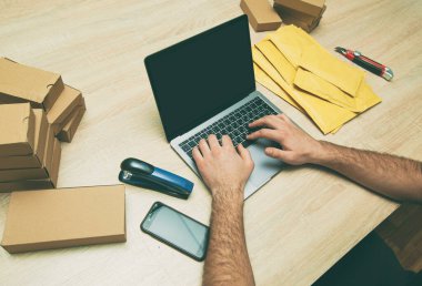 Adam ürünü sarı zarfa koyuyor.