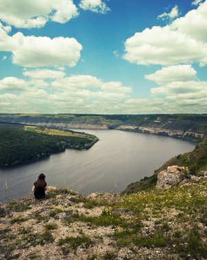 Kız uçurumun kenarında oturuyor. 
