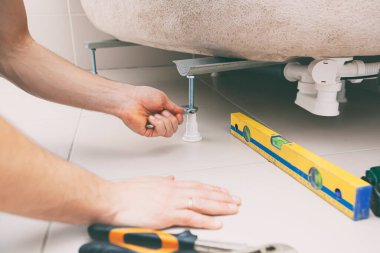 Tesisatçı banyonun yüksekliğini ayarlar.