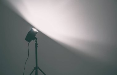 Lamba, karanlık odadaki beyaz duvarı aydınlatıyor