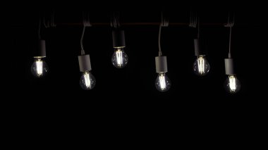 Pek çok eski lamba ahşap tahtada asılı.