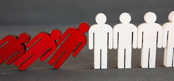 Two types of wooden persons on the wooden table: red and white