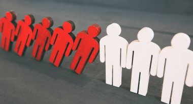 Ahşap masada iki tip ahşap insan: kırmızı ve beyaz.