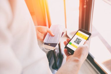 Seyahat için cep telefonunda dijital sağlık pasaport uygulaması gösteren adam.