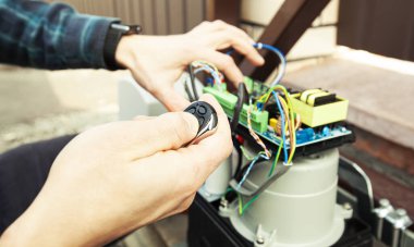 Otomatik kapının işlevini kuran ve kontrol eden teknisyen