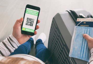 Seyahat için cep telefonunda dijital sağlık uygulaması gösteren hamile kadın..