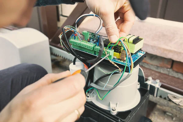 Technician man installing and checking the function of automatic gate