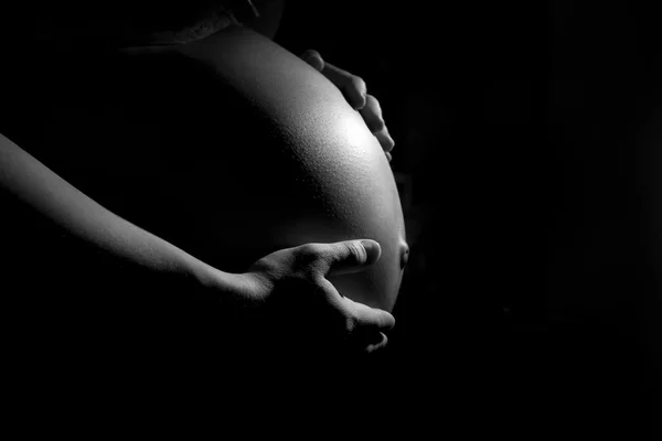 Pregnant woman belly on the dark — Stock Photo, Image