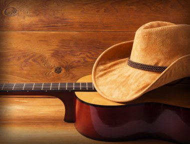 Gitar ve kovboy şapkası ahşap arka plan üzerinde