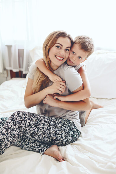 Мать играет с сыном в постели