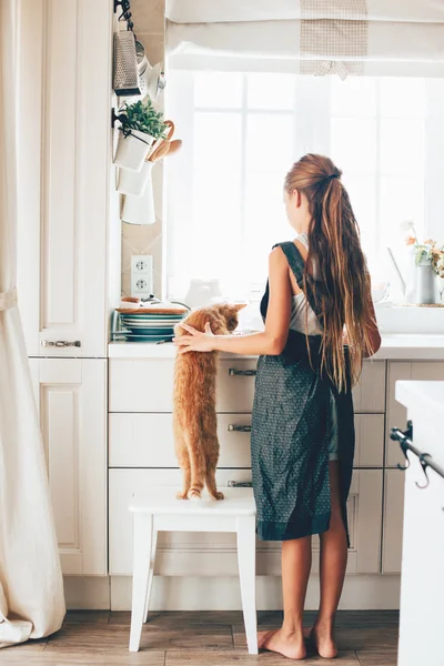 Criança com gato na cozinha — Fotografia de Stock