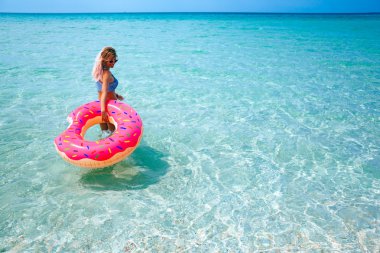 Plajda şişme yüzüğü olan kadın.