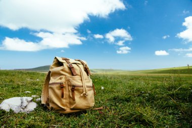 Çimenlerin üzerinde seyahat sırt çantası