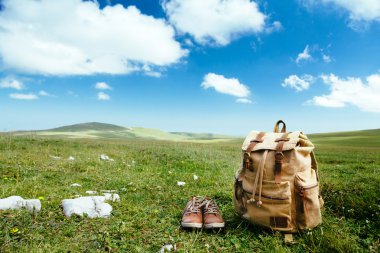 Çimenlerin üzerinde seyahat sırt çantası