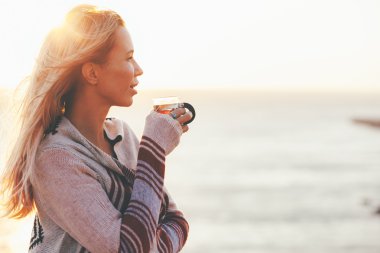 Kadın dışarıda çay içiyor.