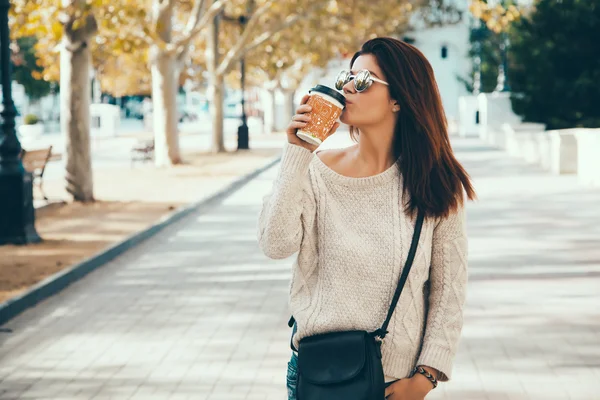 Woman walking with take away coffee