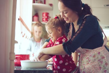 Mother with kids at the kitchen clipart