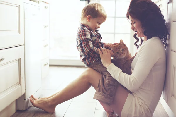 Madre e bambino giocare con gatto Immagine Stock