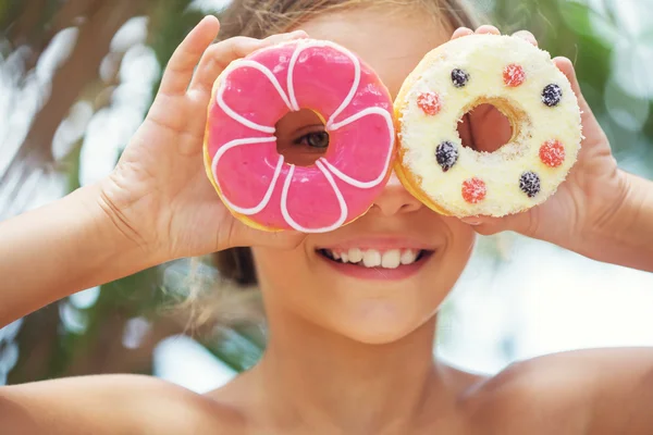 Ragazza mangiare ciambelle — Foto Stock