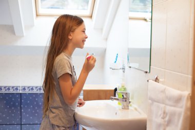 Kız dişlerini fırçalıyor.