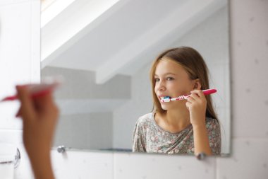 Kız dişlerini fırçalıyor.