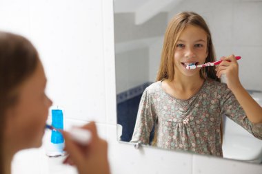 Kız dişlerini fırçalıyor.