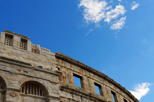 Kondenzcsík, a a sugárhajtású repülőgép felett ősi római amfiteátrum, Pula, Horvátország — Stock Fotó