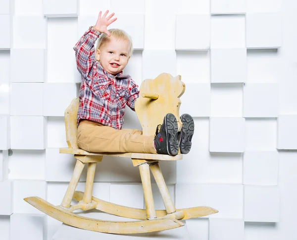 Niño montando en el caballo de juguete — Foto de Stock