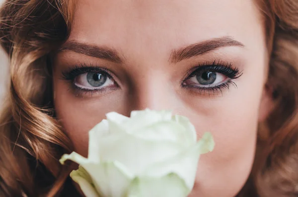 Hermosa mujer sosteniendo rosa blanca — Foto de Stock