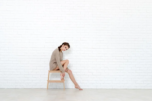 Beautiful brunette woman with wooden chair — Stock Photo, Image