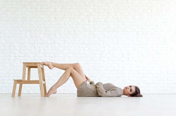 Mooie brunette vrouw met houten stoel — Stockfoto