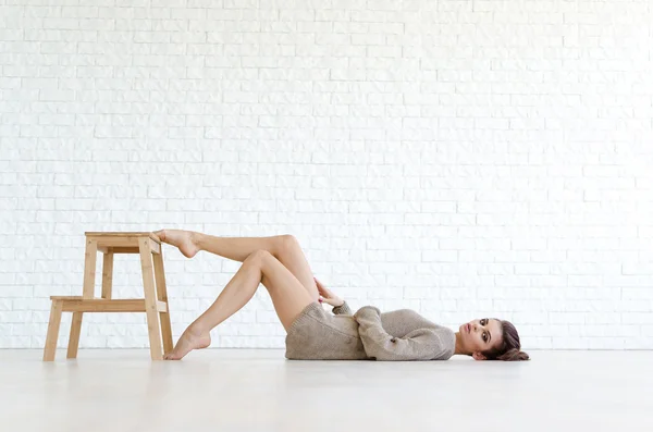 Beautiful brunette woman with wooden chair — Stock Photo, Image