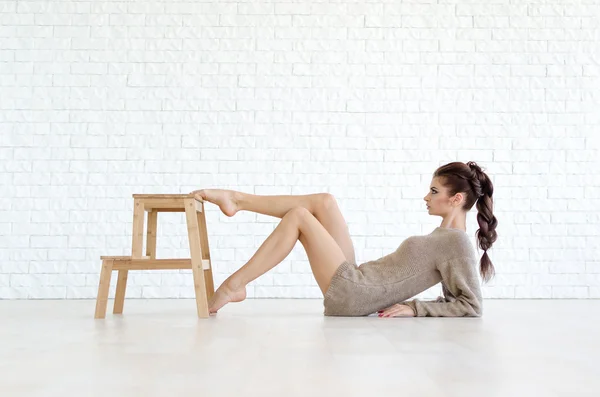 Piękna Brunetka kobieta z drewniane krzesło — Zdjęcie stockowe