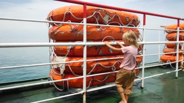 A child stands on a ferry near the rescue boats — Stock Video