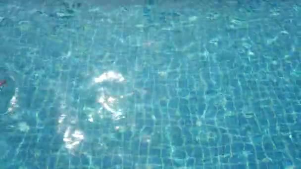 Az óvodás gyermek úszik és merül egy üres medencében — Stock videók